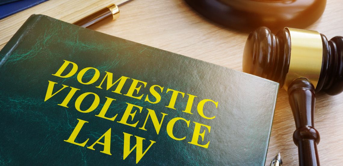 Domestic violence law book on a wooden table.